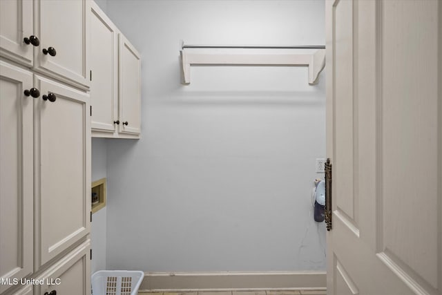 washroom featuring baseboards, cabinet space, and washer hookup