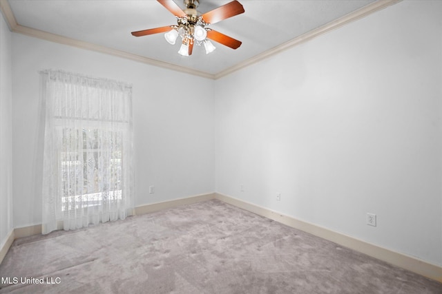 carpeted empty room with a ceiling fan, baseboards, and ornamental molding