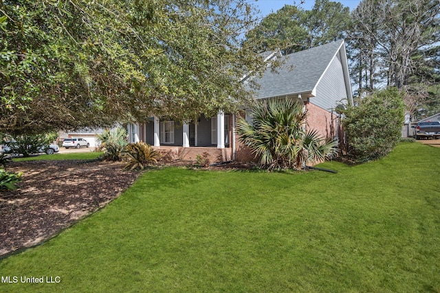 exterior space featuring brick siding and a front yard