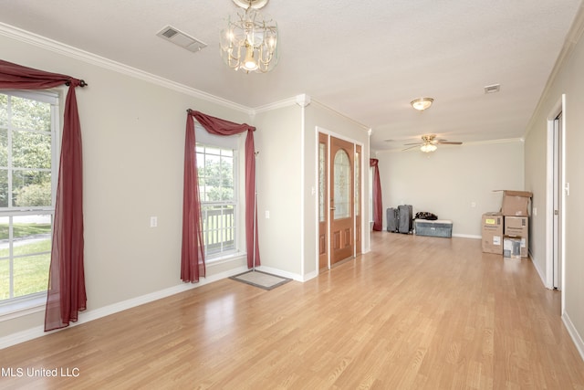 unfurnished room featuring ornamental molding, light wood-type flooring, and a wealth of natural light