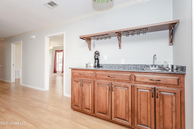 kitchen with light hardwood / wood-style flooring, sink, and crown molding