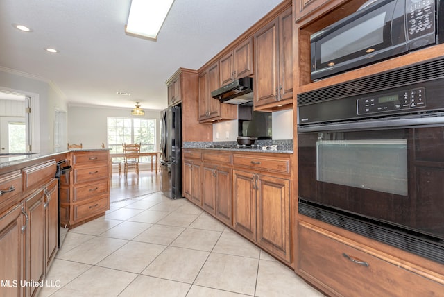 kitchen featuring light tile patterned flooring, ornamental molding, black appliances, and dark stone counters