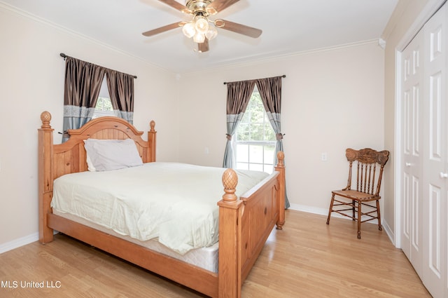 bedroom featuring ornamental molding, light wood-type flooring, a closet, and ceiling fan