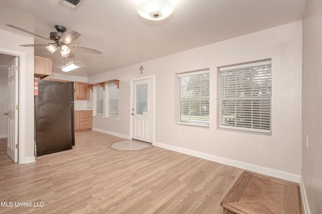 kitchen featuring ceiling fan, light hardwood / wood-style flooring, light brown cabinets, and black fridge