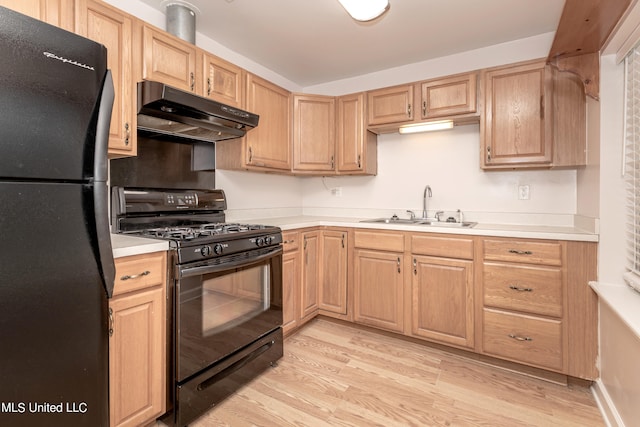 kitchen with light brown cabinetry, black appliances, sink, and light wood-type flooring