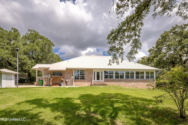 rear view of property featuring a yard and a sunroom