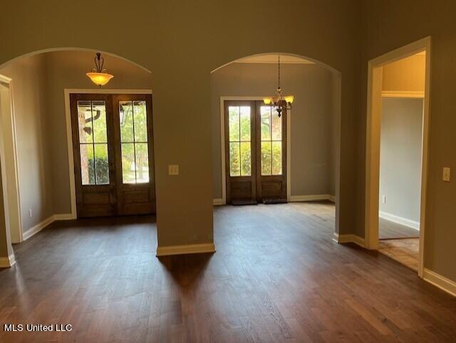 entrance foyer featuring french doors, a chandelier, and dark hardwood / wood-style floors