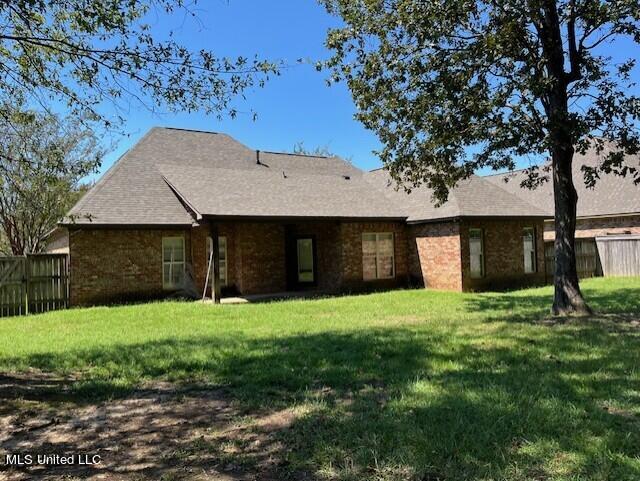 rear view of property featuring a yard