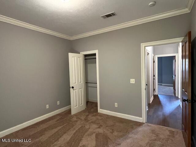 unfurnished bedroom with ornamental molding and dark carpet