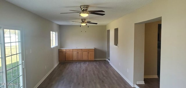 spare room featuring dark wood-style floors, baseboards, and a textured ceiling