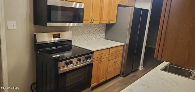 kitchen featuring wood finished floors, tasteful backsplash, and stainless steel appliances