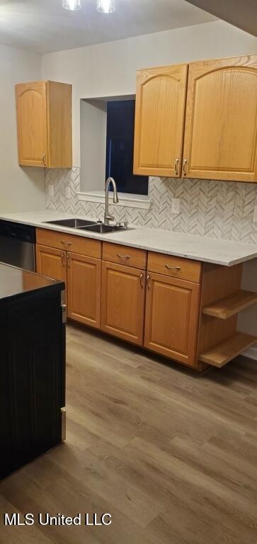 kitchen with a sink, light wood-style floors, dishwasher, and light countertops