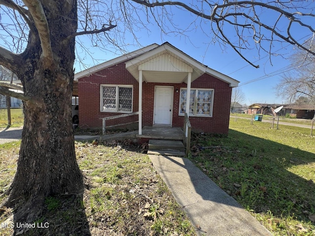 bungalow-style home with brick siding and a front lawn