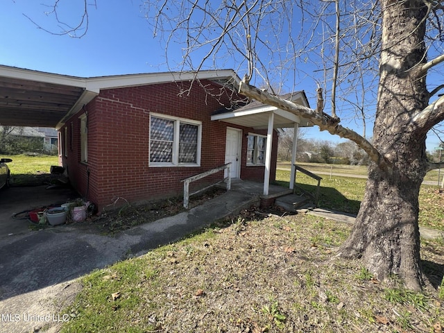 bungalow-style home featuring an attached carport and brick siding