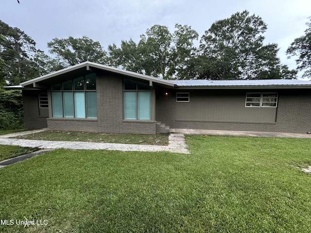 600 Jackson Ave, Mccomb, MS 39648 - view of front of home with a front yard, brick siding, and a metal roof