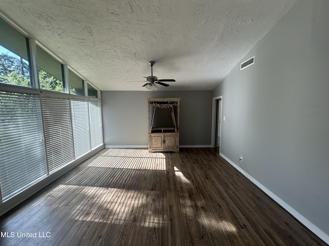 600 Jackson Ave, Mccomb, MS 39648 - unfurnished living room featuring a textured ceiling, a ceiling fan, floor to ceiling windows, dark wood finished floors, and lofted ceiling