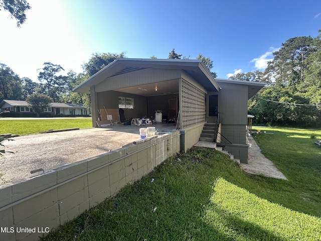 600 Jackson Ave, Mccomb, MS 39648 - view of property exterior with concrete driveway, a yard, a carport, entry steps, and a patio