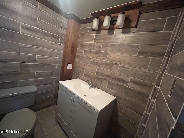 600 Jackson Ave, Mccomb, MS 39648 - half bathroom featuring tile walls, vanity, and tile patterned floors