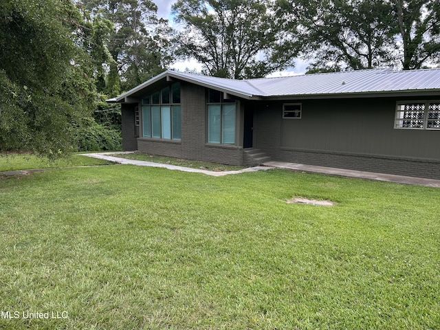 600 Jackson Ave, Mccomb, MS 39648 - view of front facade featuring a front yard, brick siding, and a metal roof