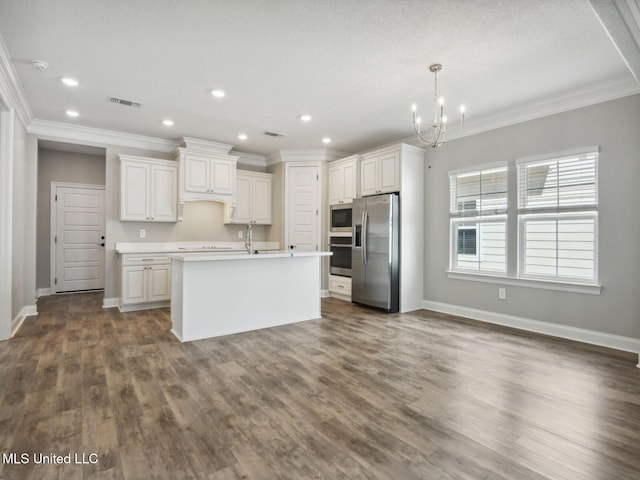 kitchen featuring a notable chandelier, light countertops, ornamental molding, white cabinets, and appliances with stainless steel finishes