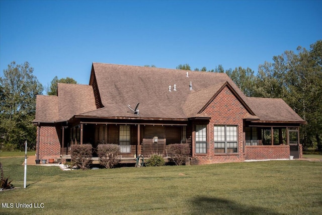 rear view of house featuring a shingled roof, brick siding, and a lawn