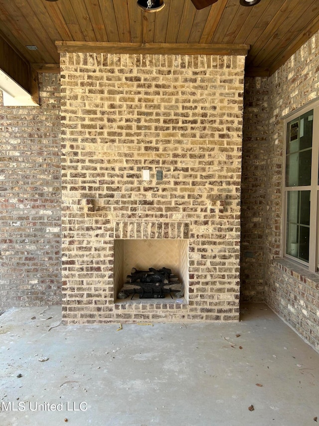 unfurnished living room featuring wooden ceiling and brick wall