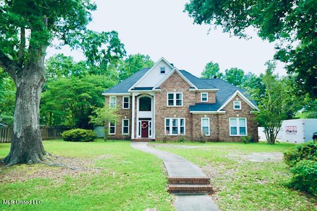 view of front of home with fence and a front lawn