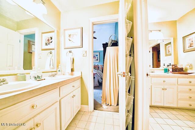 full bath with double vanity, tile patterned floors, and ensuite bathroom