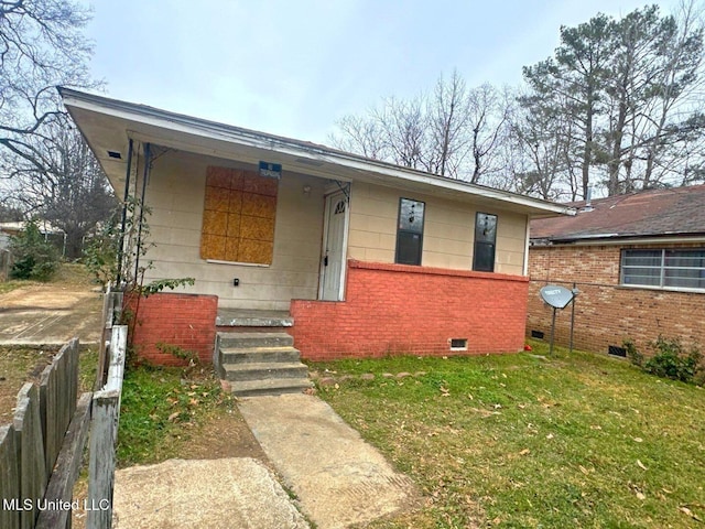 bungalow-style house with crawl space, covered porch, fence, a front yard, and brick siding