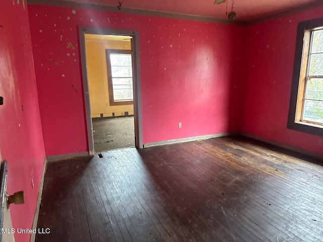 spare room with hardwood / wood-style flooring and baseboards