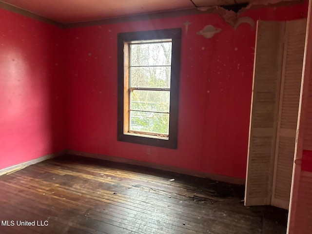 empty room with baseboards and hardwood / wood-style flooring