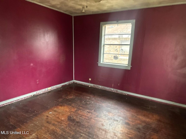 empty room with wood-type flooring and baseboards