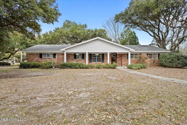 ranch-style house featuring covered porch and brick siding