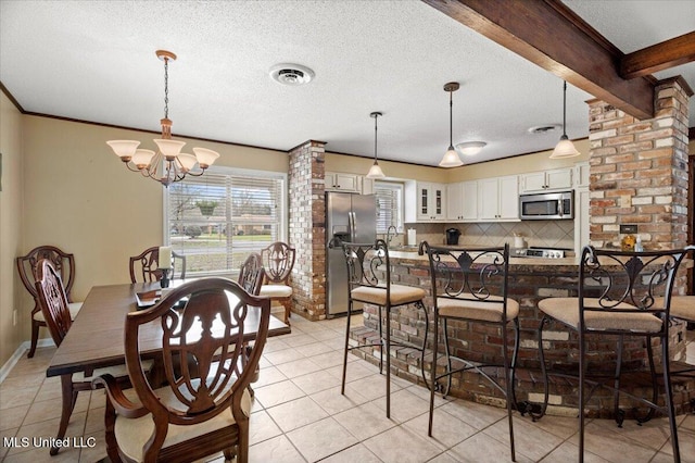 dining room featuring a chandelier, light tile patterned flooring, beamed ceiling, and a textured ceiling