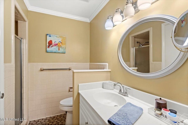 full bathroom featuring a stall shower, a wainscoted wall, ornamental molding, vanity, and tile walls