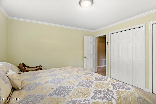 carpeted bedroom featuring ornamental molding, a closet, visible vents, and baseboards