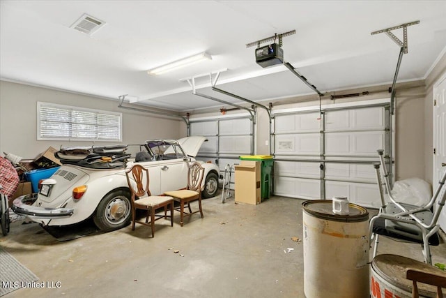 garage featuring a garage door opener and visible vents