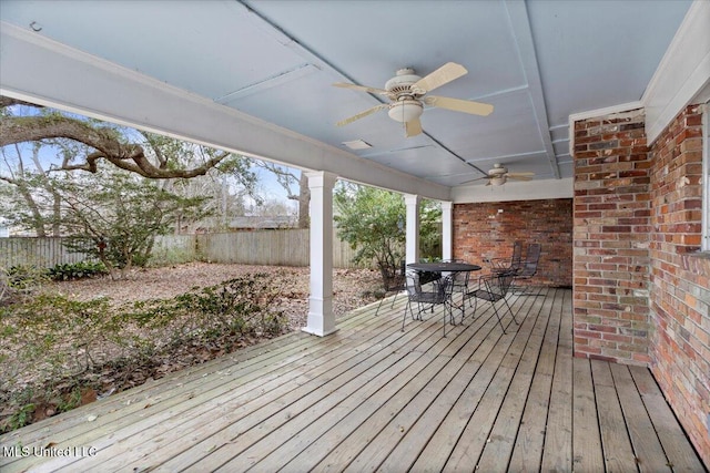 deck with outdoor dining area, a fenced backyard, and ceiling fan