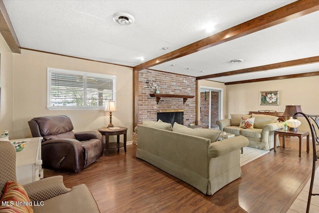 living area with a textured ceiling, a fireplace, dark wood-type flooring, and beamed ceiling