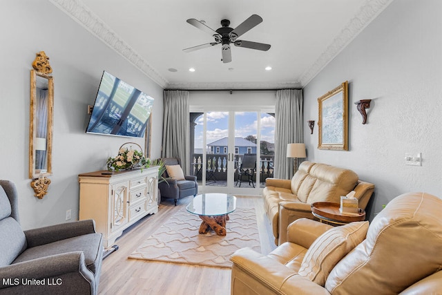 living room featuring light hardwood / wood-style flooring, ceiling fan, and crown molding