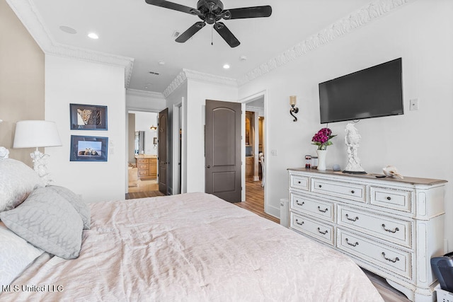 bedroom featuring ensuite bathroom, light hardwood / wood-style flooring, ornamental molding, and ceiling fan