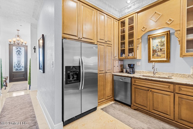 kitchen with light stone counters, stainless steel appliances, a textured ceiling, an inviting chandelier, and sink