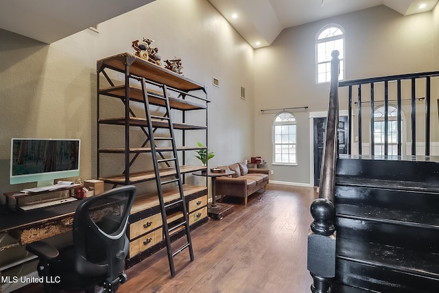 office with high vaulted ceiling, hardwood / wood-style floors, and a wealth of natural light