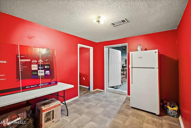 kitchen featuring a textured ceiling and white refrigerator