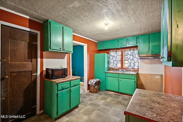 kitchen with green cabinets, sink, a textured ceiling, and ornamental molding