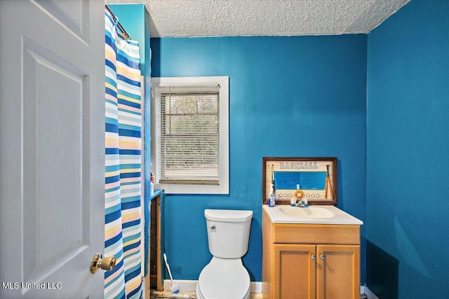 bathroom featuring vanity, a textured ceiling, and toilet