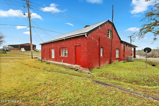 view of home's exterior with central AC and a lawn