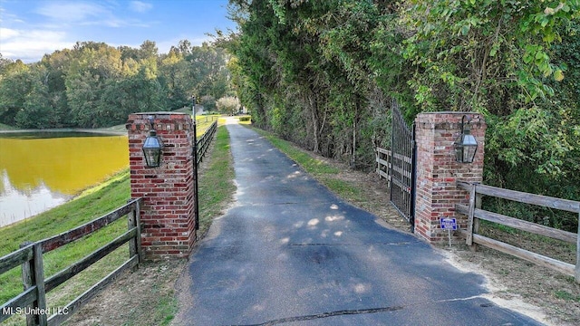 607 Tiffintown Rd, Vicksburg, MS 39183 - view of road featuring a view of trees, a water view, aphalt driveway, and a gated entry