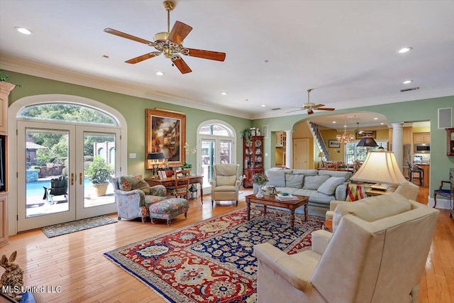 607 Tiffintown Rd, Vicksburg, MS 39183 - living area with french doors, arched walkways, a wealth of natural light, decorative columns, and ceiling fan with notable chandelier