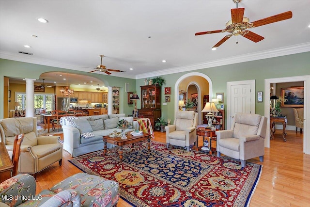 607 Tiffintown Rd, Vicksburg, MS 39183 - living room featuring light wood-type flooring, ceiling fan, arched walkways, visible vents, and decorative columns